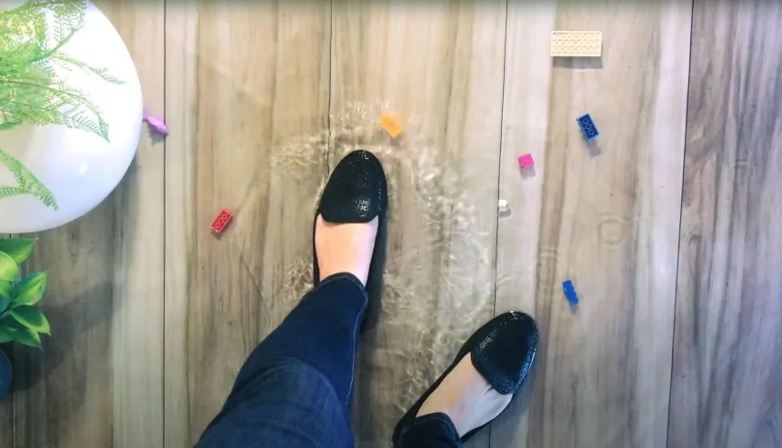 woman standing in puddle of watert in living room after a property damage emergency that caused water damage to her home in long island